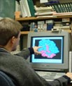 Student pointing at a computer monitor.